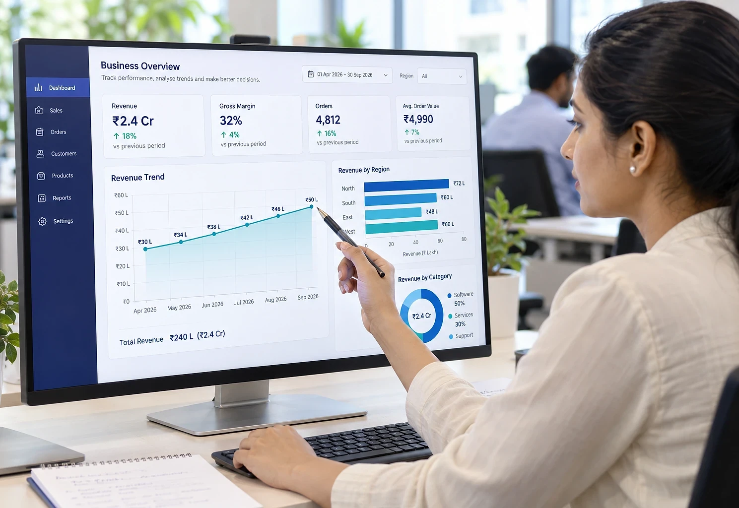 Data analyst pointing at a revenue trend on a business dashboard
