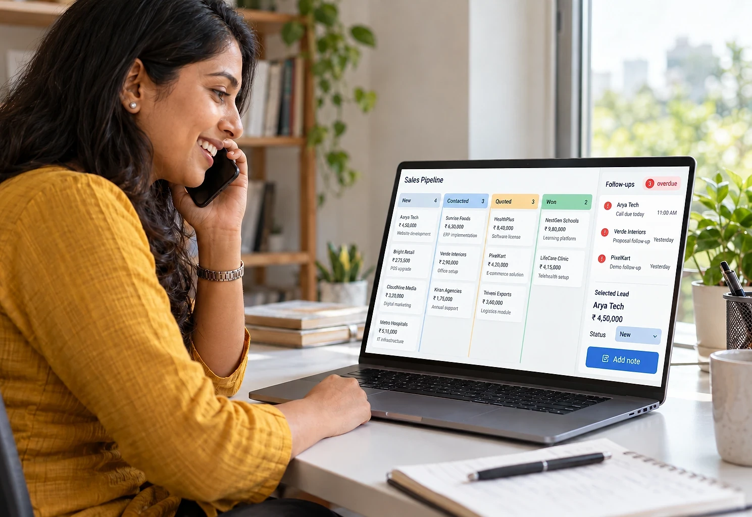 Sales executive on a call while her laptop shows the lead pipeline and today's follow-ups