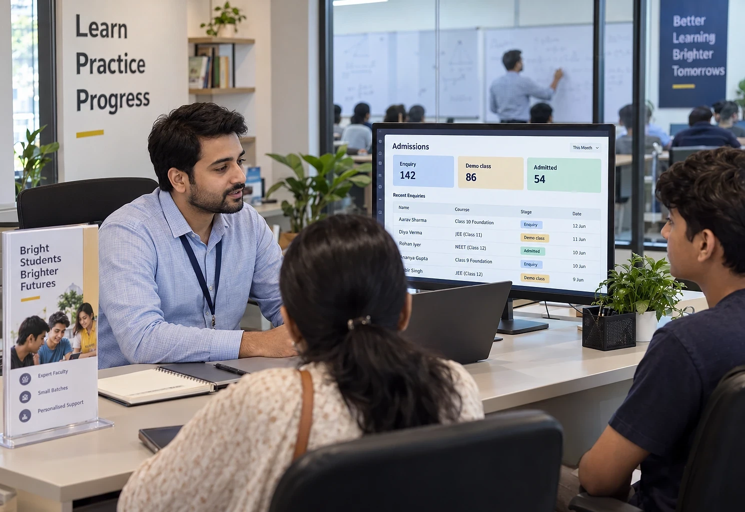 Admissions counsellor with a parent and student, an admissions pipeline on his monitor